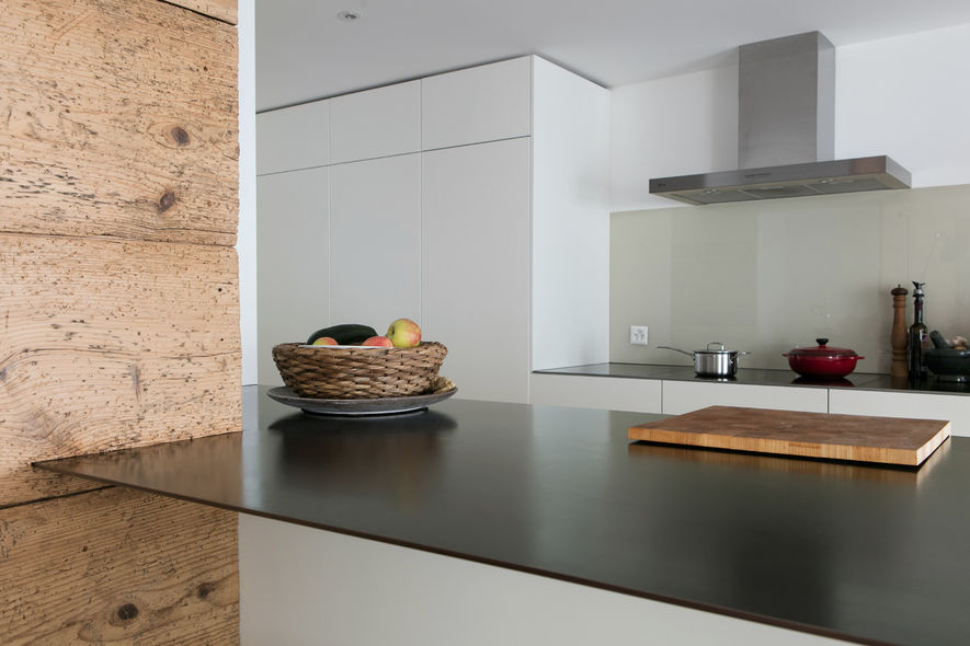 Die Holzbretter des Bauern­hauses kontrastieren mit den Stahlplatten der Küchenabdeckung.